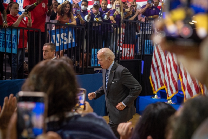 President Biden entering auditorium as he takes to the stage